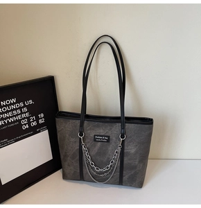 Détail d'un sac cabas gris foncé avec texture marbrée et triple chaîne métallique