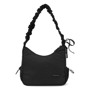 Detail of a black nylon crescent bag with ruched handle and bow accents on white background