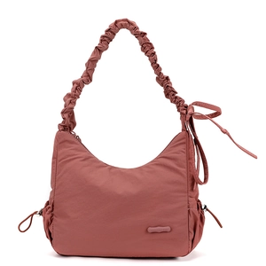 Close-up of pink nylon crossbody bag showing the drawstring detail and ruched texture