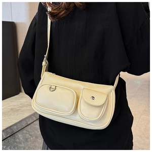 Close-up of yellow shoulder bag featuring unique dual front pockets and silver ring detail
