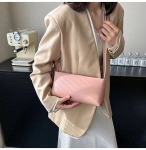 Detail of minimalist pale pink baguette bag in premium faux leather with slim strap