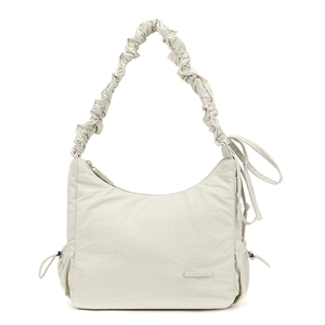Detail of nylon crossbody bag featuring drawstring side pockets and a branded logo patch