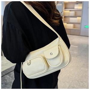 Detail showing cream vintage shoulder bag with textured leather and unique multi-pocket design
