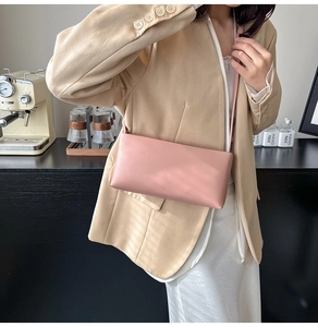 Chic pink rectangular shoulder bag showcased by a model in elegant minimalist beige attire