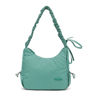 Close-up of mint green nylon shoulder bag with ruffled strap and ribbon bow detail