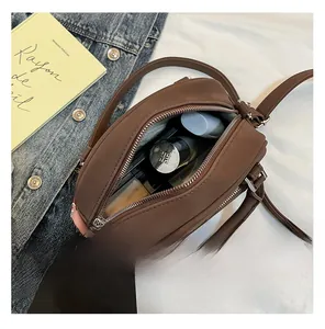 Vue de dessus de l'intérieur d'un sac bowling marron avec cosmétiques et rouge à lèvres