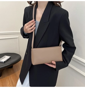 Chic earth-toned rectangular shoulder bag with slim strap styled in a minimalist setting