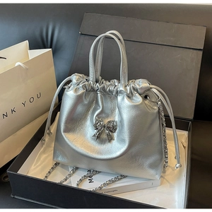 Silver pleated drawstring bag with metallic bow detail inside a premium gift box