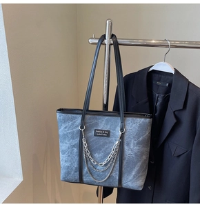 Détail du sac cabas à texture marbre bleu avec chaîne argentée et étiquette
