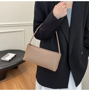 Chic khaki leather underarm bag styled with a minimalist outfit in a modern interior