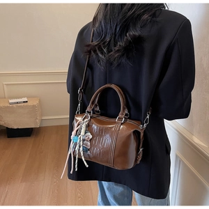 Brown Boston bag with 'CHEERFUL TIME' embossing, bear pendant and woven charm detail