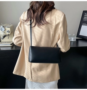 Rear view of model wearing a minimalist black matte leather shoulder bag for daily commuting