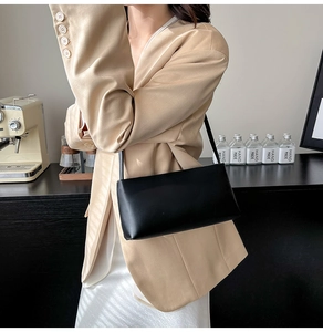 Chic black matte leather underarm bag styled with a modern beige blazer for women