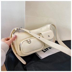 Detailed macro view of white shoulder bag with dual exterior pockets and silver metal hardware