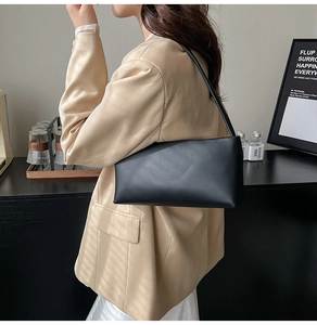 Minimalist black leather underarm bag styled with a beige blazer for a modern look
