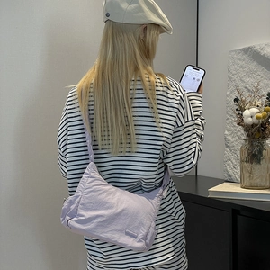 Detailed back view of a lavender nylon crossbody bag with adjustable wide shoulder strap
