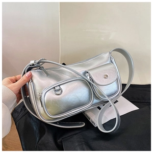 Close-up of metallic silver square bag with dual pockets and adjustable strap details