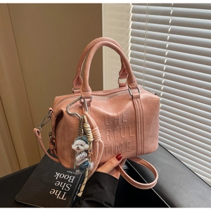 Detail of pink Boston bag with Cheerful Time embossing and cute puppy pendant charm