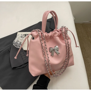 Detailed view of pink leather texture with silver metal bow and drawstring closure