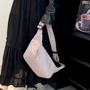 Détail du sac bandoulière en nylon rose avec double fermeture éclair et sangle réglable