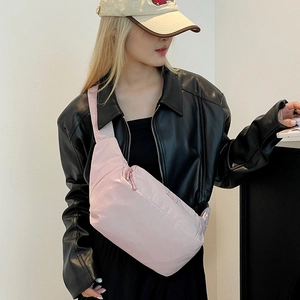 Détail du sac de poitrine en nylon rose porté par un modèle pour un style décontracté