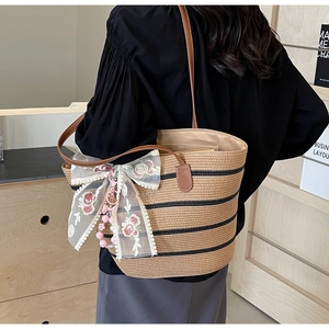 Detail der Strohtasche mit schwarzen Streifen, Spitzenbogen und Blumenstickerei