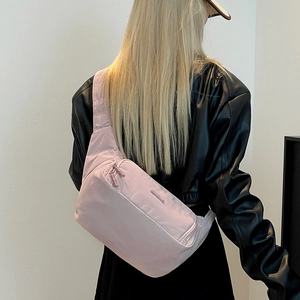 Détail d'un sac bandoulière en nylon rose clair avec tissu résistant à l'eau et fermeture