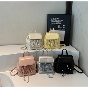 Detailed display of five colorful mini leather backpacks featuring pearl drawstring accents