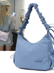 Blue nylon crossbody bag with ruched strap and small lavender version on model