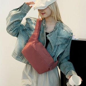 Détail du sac de poitrine en nylon rose foncé avec fermetures éclair et bandoulière large