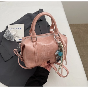 Detail of pink Boston bag with Cheerful Time embossing and decorative cat charm