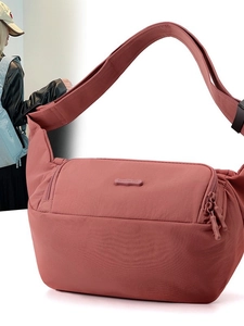 Sac bandoulière en nylon rose Morandi avec sangle large et logo en relief dans un studio doux