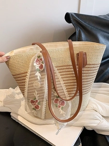 Straw tote bag with striped weave pattern, floral lace detail, and faux leather handles