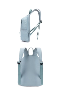 Detail view of mint green nylon backpack showing adjustable straps and side pockets