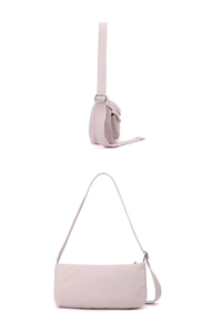 Detail of light pink nylon bag featuring adjustable shoulder strap and silver hardware