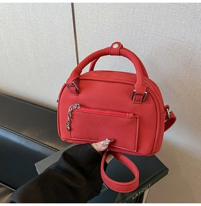 Vista dall'alto della borsa a bauletto rossa opaca con catena argento e tracolla