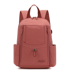 Front view of a coral pink nylon backpack featuring multi-pockets and a brand tag