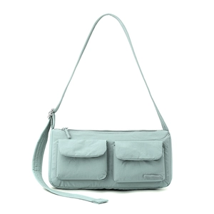 Detail of mint green nylon bag showing dual magnetic pockets and adjustable strap