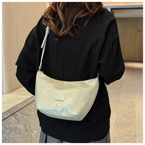 Detailed view of half-moon hobo bag showing refined faux leather texture and brand logo