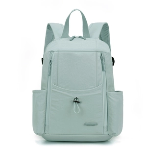 Detail of mint green nylon backpack showing front pocket with drawstring buckle and logo