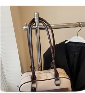 Detail of reinforced handles and stitching on the beige and brown bowling bag