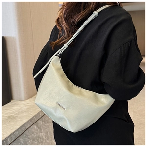 Detail of light green crescent shoulder bag with metallic logo and adjustable strap