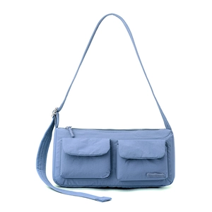 Detail of light blue nylon messenger bag featuring waterproof fabric and two front pockets
