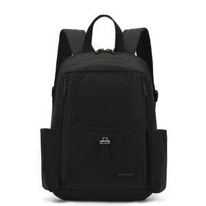 Detail view of black nylon backpack with multi-pocket design and water-resistant texture
