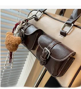 Detail of vintage Boston bag with leather texture, side pockets, and brown plush bear charm