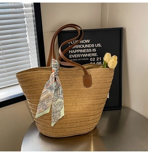 Detailed texture of straw woven tote with leather handles and decorative silk scarf