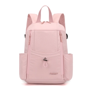 Detail of pink nylon backpack showing water-resistant fabric and large front zipper pocket