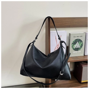 Detailed close-up of a black hobo shoulder bag with textured pleats and adjustable strap