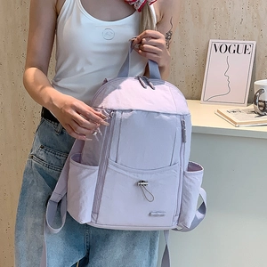 Detail of lavender nylon backpack featuring multiple functional zipper compartments