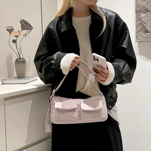 Detail of light pink nylon messenger bag with two utility front pockets for women